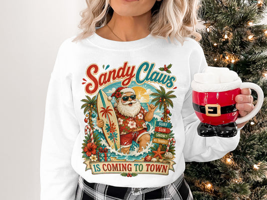 Crewneck sweatshirt with surfing Santa, palm trees, and "Sandy Claws is Coming to Town" text.