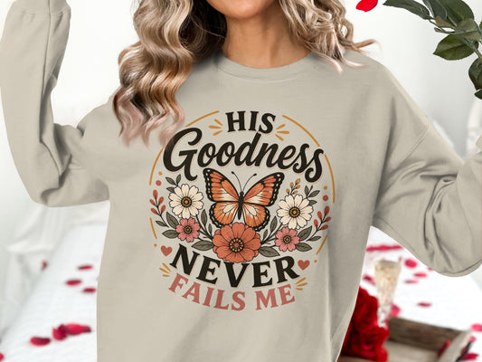 Beige sweatshirt with "His Goodness Never Fails Me" text and butterfly graphic.