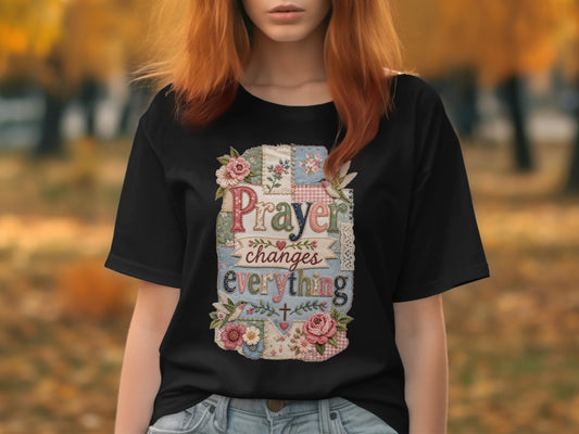 Black t-shirt with "Prayer changes everything" text and floral patchwork design.