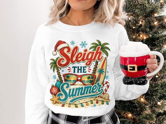 White sweatshirt with "Sleigh the Summer" graphic featuring Santa hat, palm trees, and surfboard.