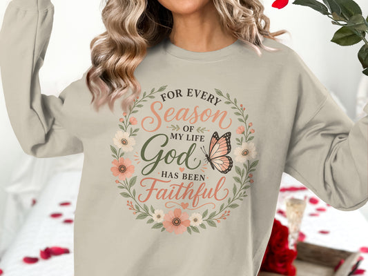 Crewneck sweatshirt with floral wreath, butterfly, and "God has been faithful" text.