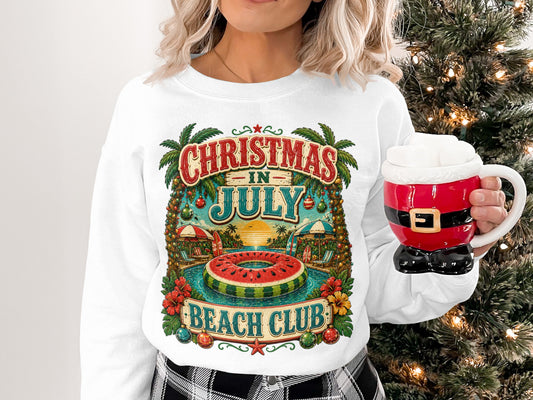 Woman in white sweatshirt with "Christmas in July Beach Club" graphic and Santa mug.