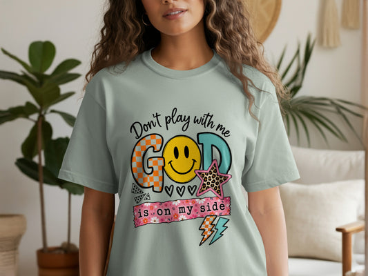 Light green t-shirt with "Don't play with me GOD is on my side" text and graphics.