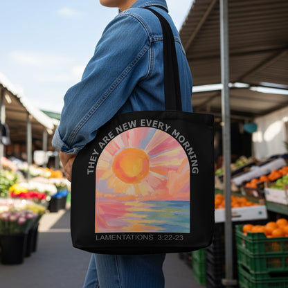 Black tote bag with sun and ocean artwork and text "THEY ARE NEW EVERY MORNING"