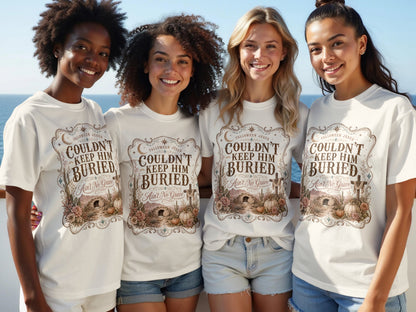 Four women wear white t-shirts with a "Couldn't Keep Him Buried" graphic.