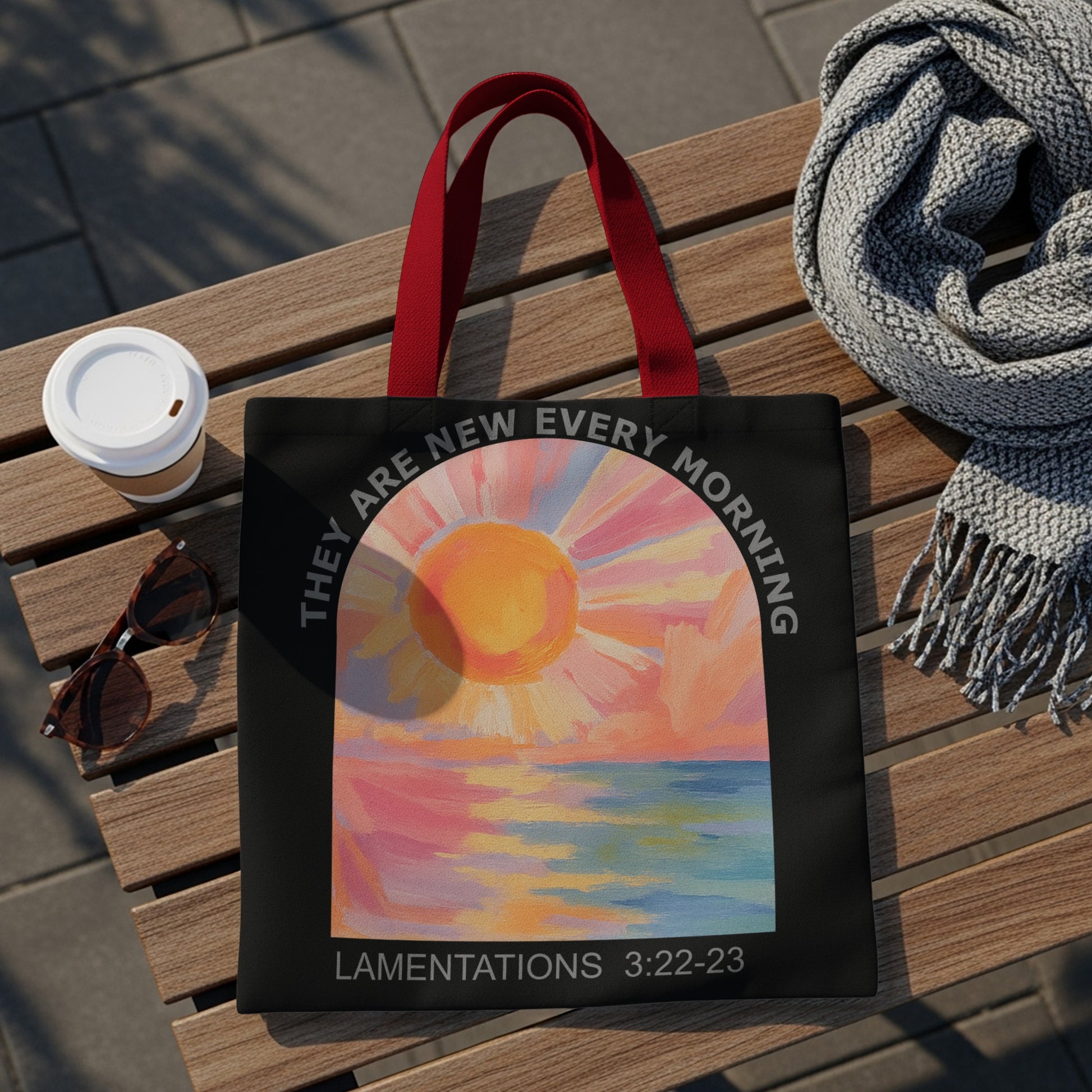Black tote bag with a sunrise over water painting and "LAMENTATIONS 3:22-23" text.