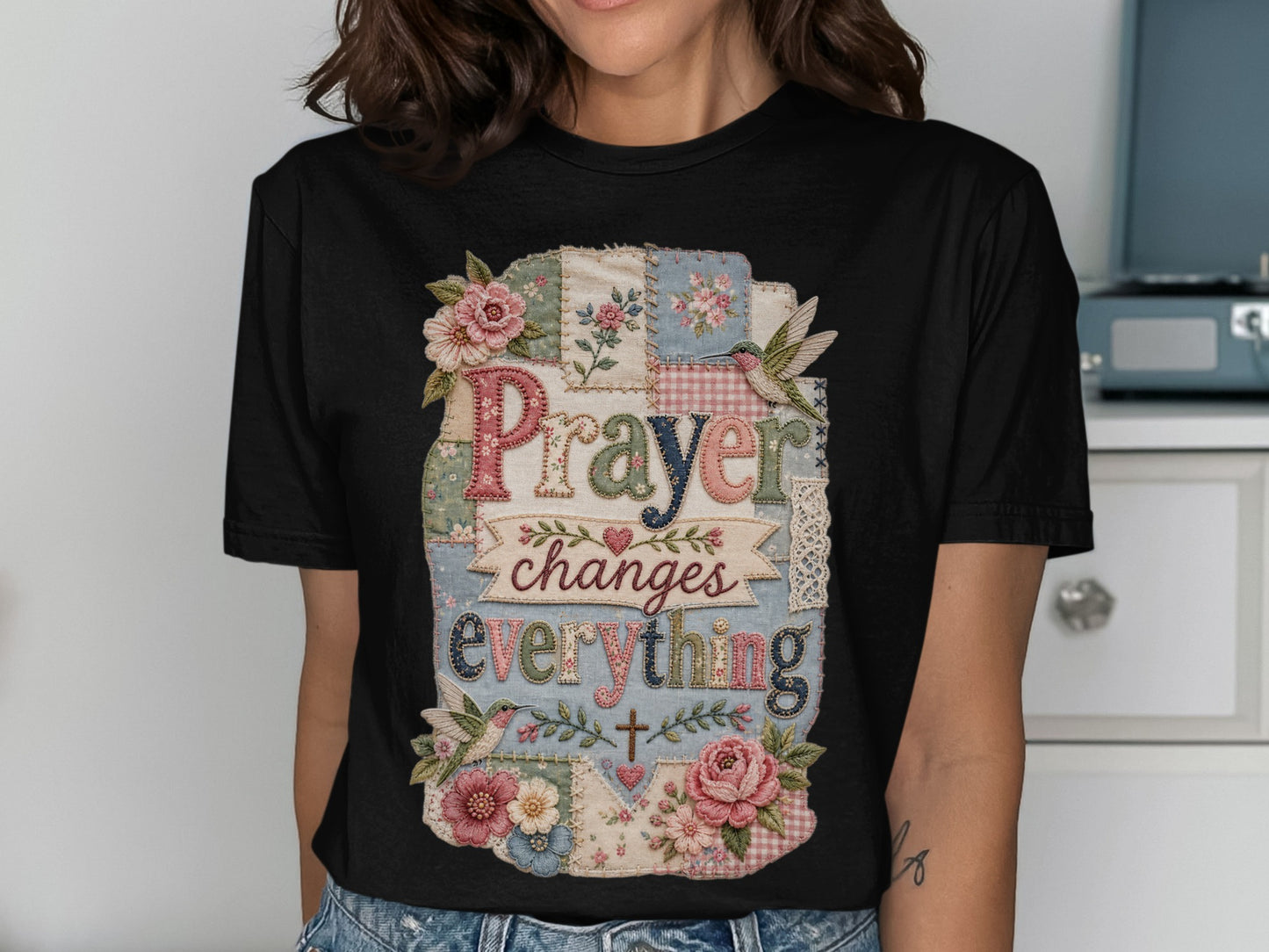 Black t-shirt with patchwork design and text "Prayer changes everything".