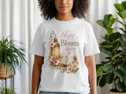 White t-shirt with a floral design and gold lantern, reading "Hope Blooms Again".