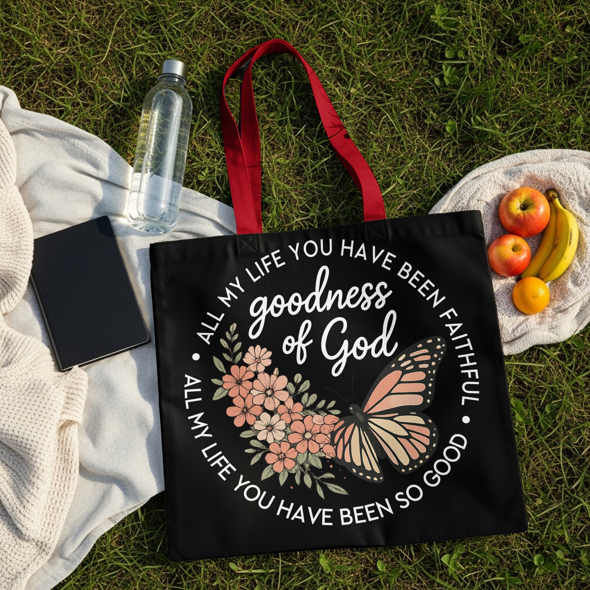 Black tote bag with butterfly and floral design, text "goodness of God" and "ALL MY LIFE YOU HAVE BEEN FAITHFUL ALL MY LIFE YOU HAVE BEEN SO GOOD".