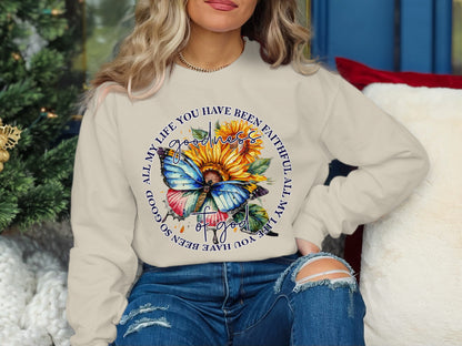 Cream sweatshirt with a butterfly and sunflower graphic, featuring text.