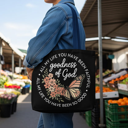 Black tote bag with "goodness of God" and floral butterfly design.