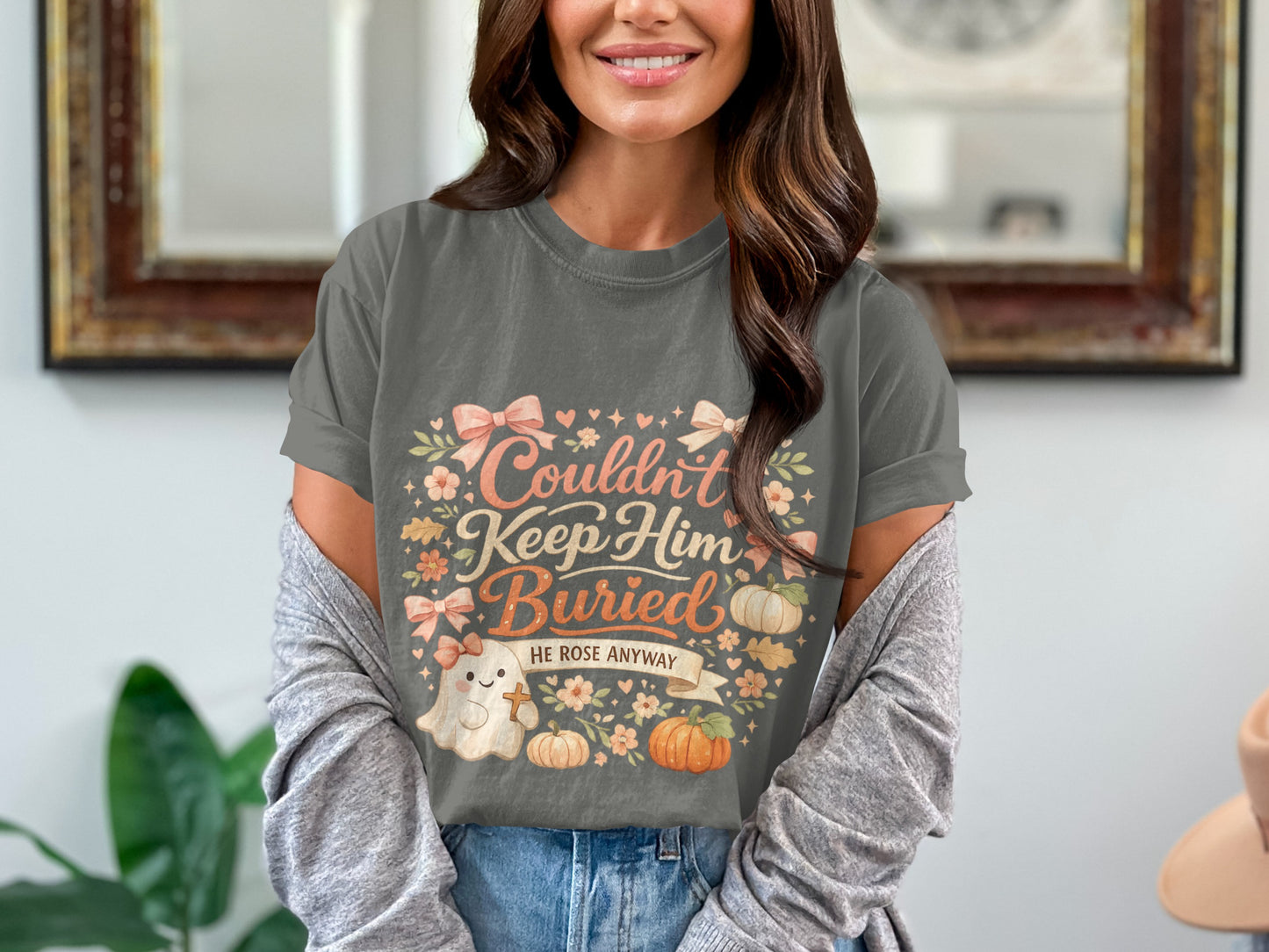 T-shirt with "Couldn't Keep Him Buried He Rose Anyway" text, ghost, and pumpkins.