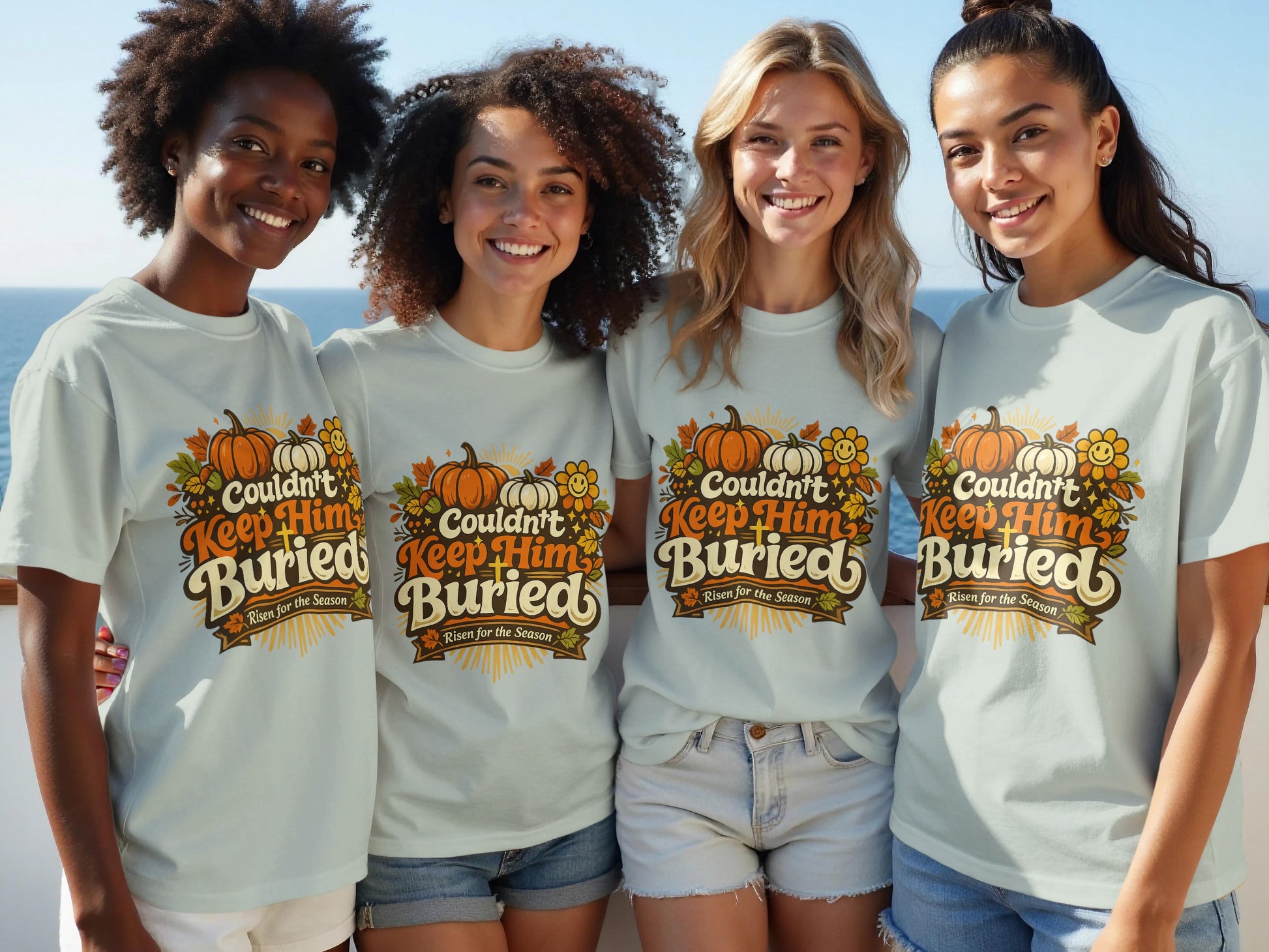 Four women wear light blue t-shirts with a graphic featuring pumpkins, leaves, and text "Couldn't Keep Him Buried. Risen for the Season."