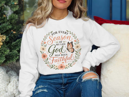 White sweatshirt with floral wreath and "For every season of my life God has been faithful" text.