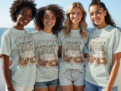 Four women wear light blue t-shirts with "Couldn't Keep Him Buried, Ain't No Grave" graphic.