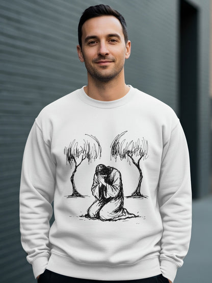 Man wearing white sweatshirt with drawing of Jesus kneeling between two trees.