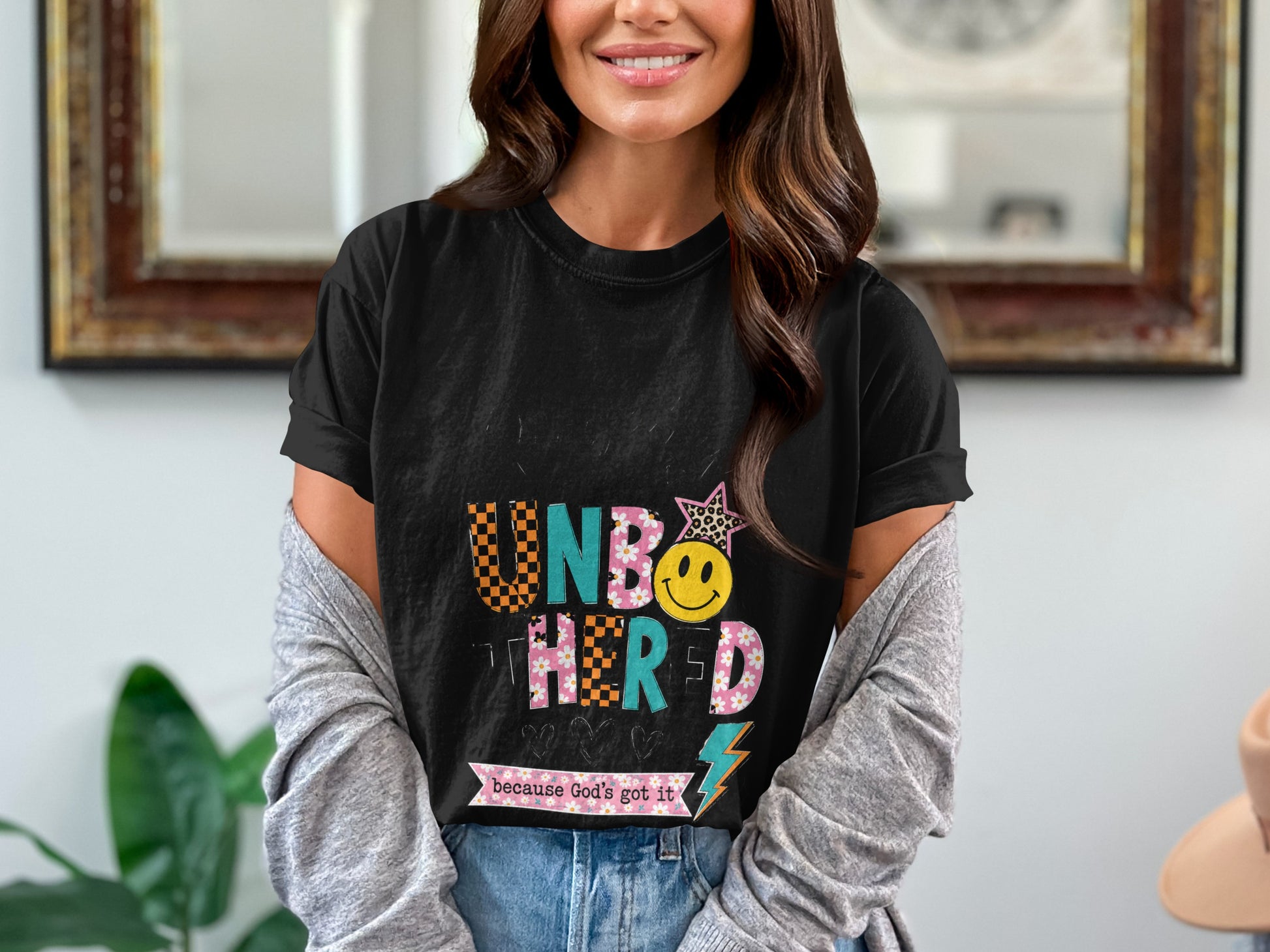 Black t-shirt with "Unbothered because God's got it" text and graphics.