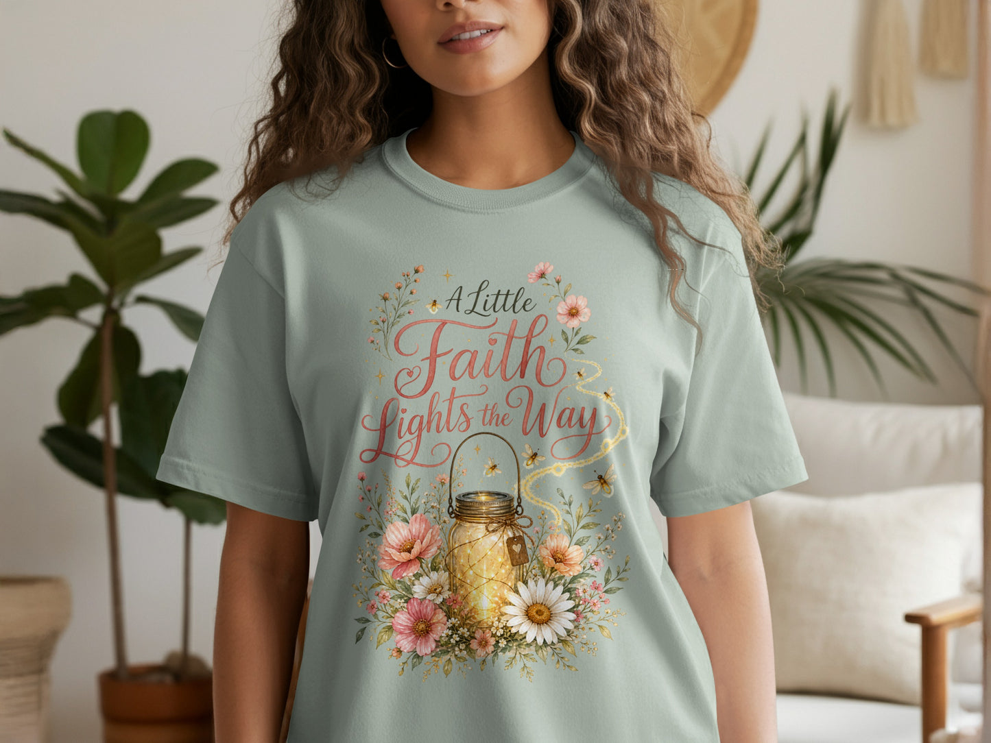 Light green t-shirt with "A Little Faith Lights the Way" and lantern floral design.