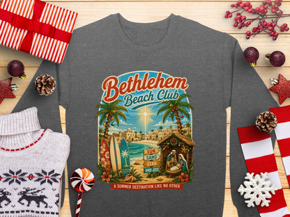 Bethlehem Beach Club graphic with a nativity scene, surfboards, palm trees, and text.