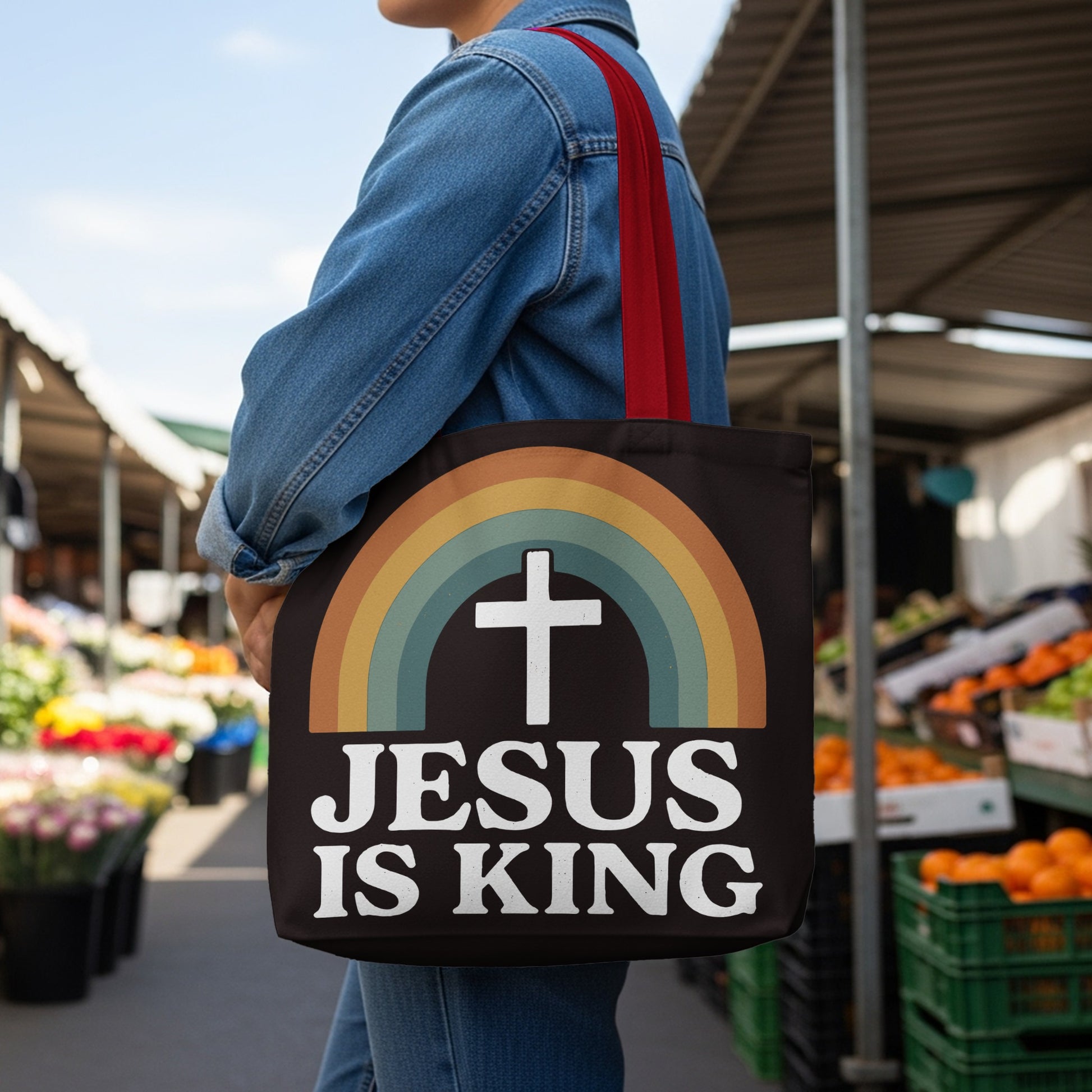 Black tote bag with rainbow and white cross graphic, text "JESUS IS KING".
