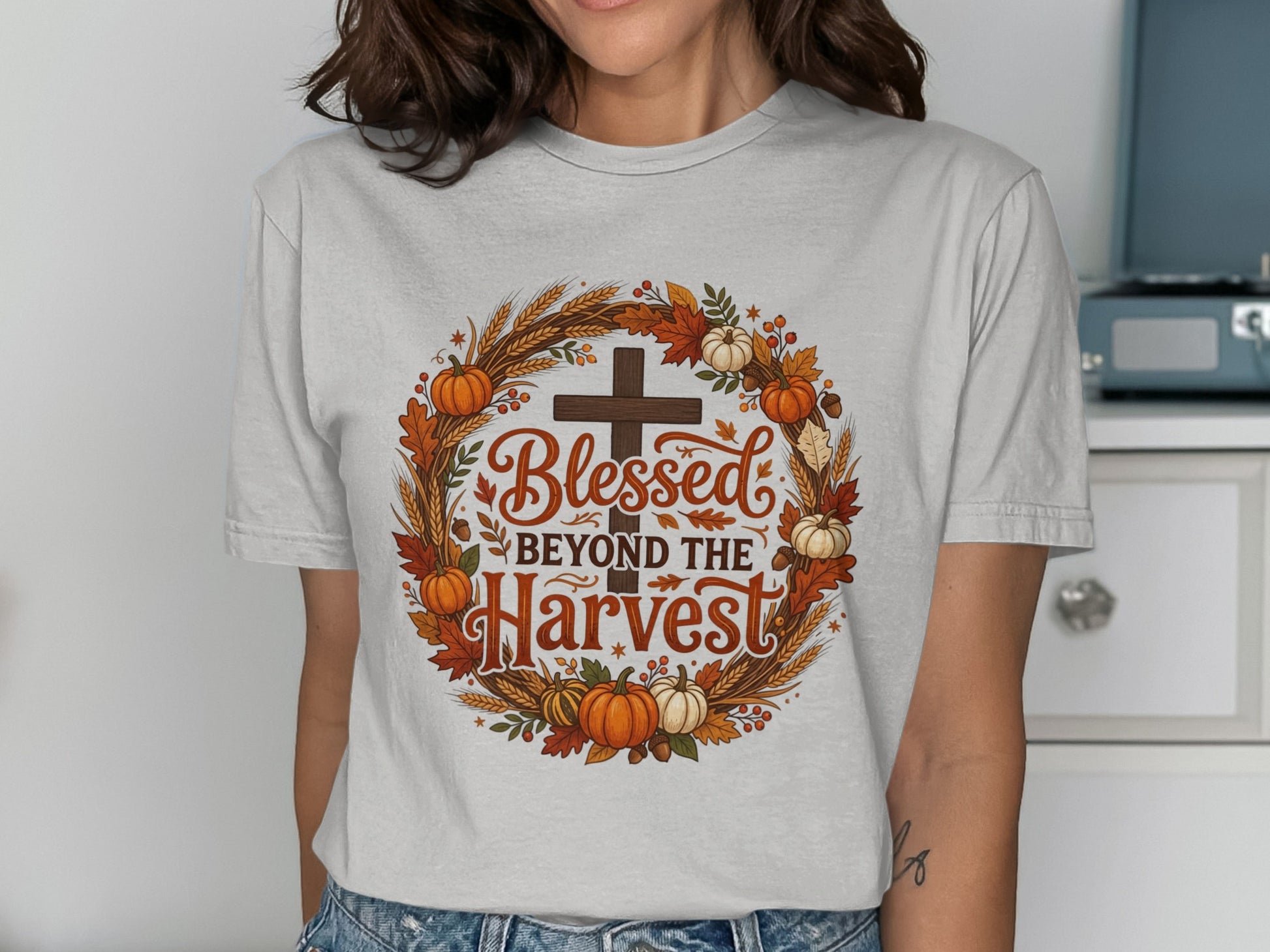 "Blessed Beyond the Harvest" text on a wreath of wheat, pumpkins, and leaves.
