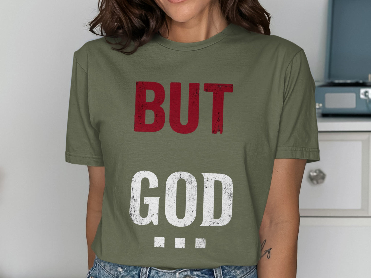 Green t-shirt with red "BUT" and white "GOD" text.