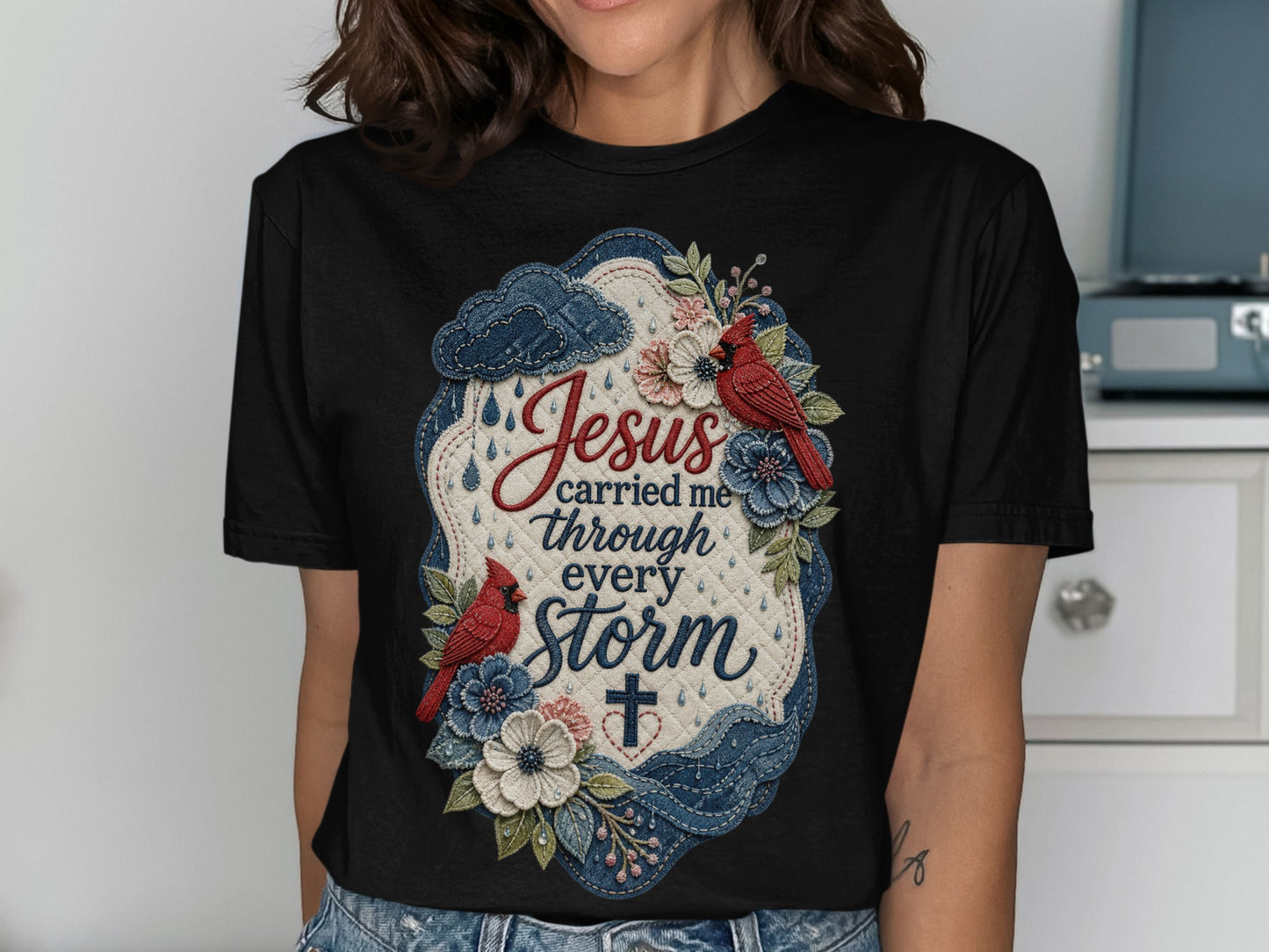 Black t-shirt with "Jesus carried me through every storm" text and floral design.