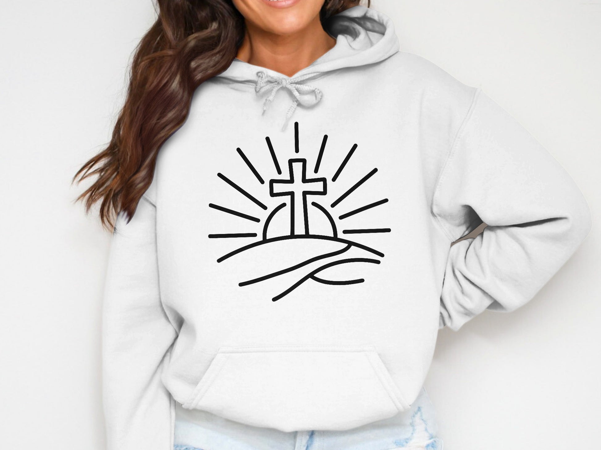 White hoodie with a black line drawing of a cross rising over a hill.
