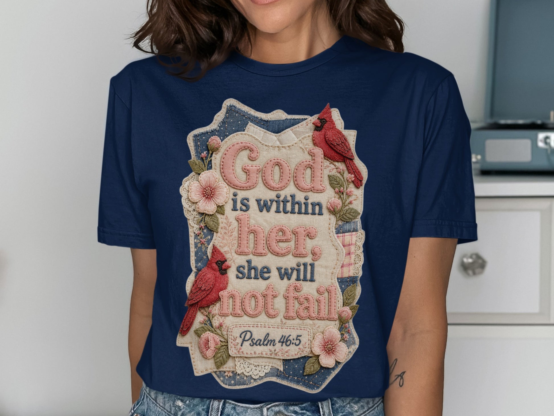 Navy t-shirt with floral accents and text "God is within her she will not fail".