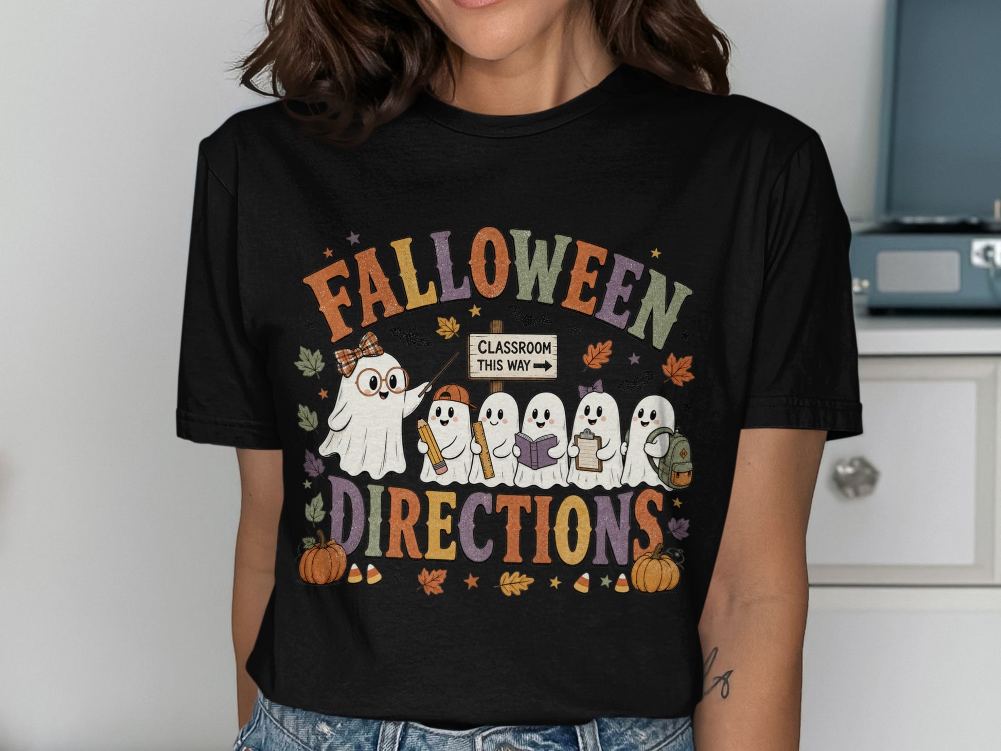 Halloween Directions t-shirt with ghosts holding school supplies and fall leaves.