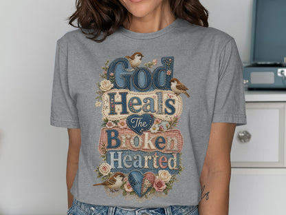 Gray t-shirt with "God Heals The Broken Hearted" text and floral accents.