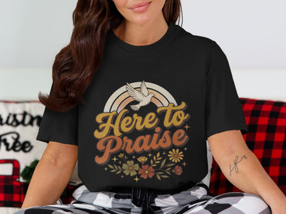Black t-shirt with "Here to Praise" text, dove, rainbow, and floral design.