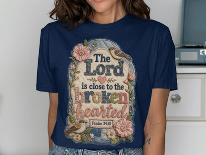 Navy t-shirt with "The Lord is close to the broken hearted" text and floral accents.