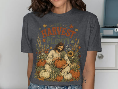Jesus holding a pumpkin surrounded by harvest vegetables and flowers.