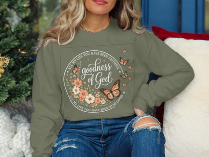 Green sweatshirt with floral wreath, butterflies, and "goodness of God" text.