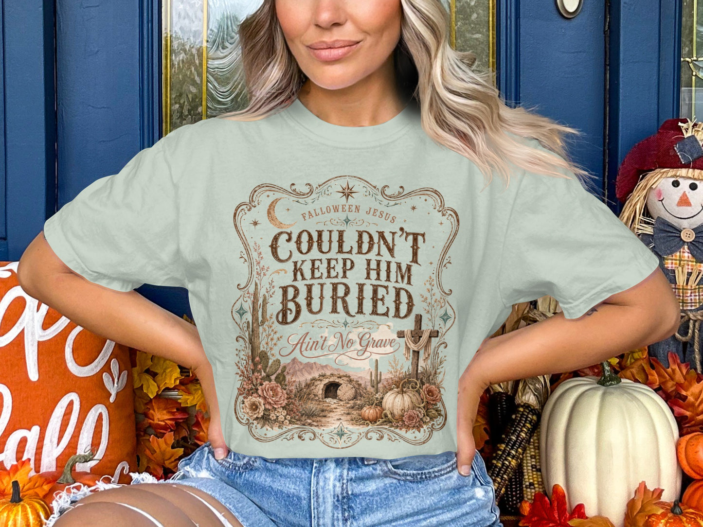 Light green t-shirt with "Fallween Jesus Couldn't Keep Him Buried Ain't No Grave" text and Easter tomb scene.