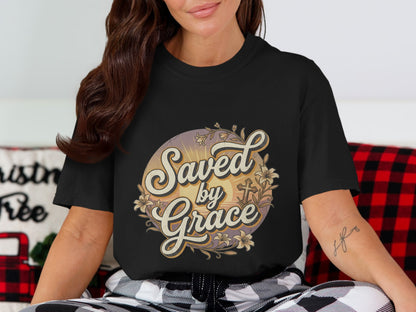 Black t-shirt with "Saved by Grace" text and floral cross graphics.