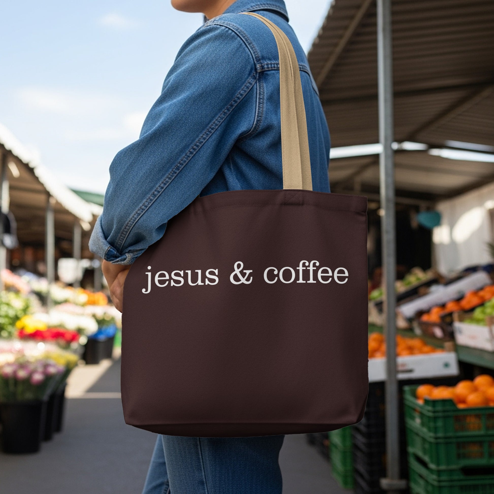Brown tote bag with white text "jesus & coffee" held by person.