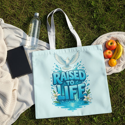 Light blue tote bag with "RAISED TO LIFE" text and a white dove.