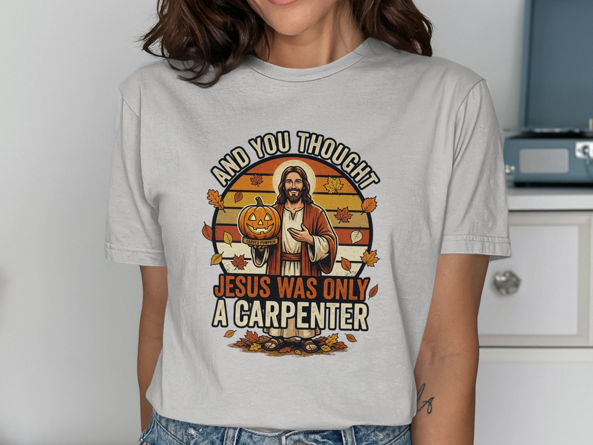 Jesus holding a jack-o'-lantern with "Jesus was only a carpenter" text.