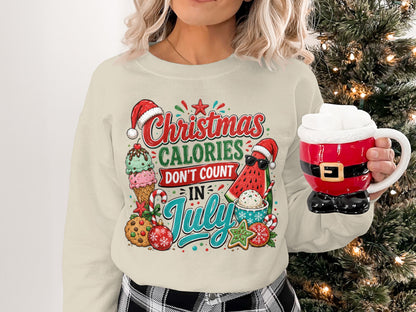 Cream sweatshirt with Christmas in July graphic featuring ice cream, watermelon, and cookies.