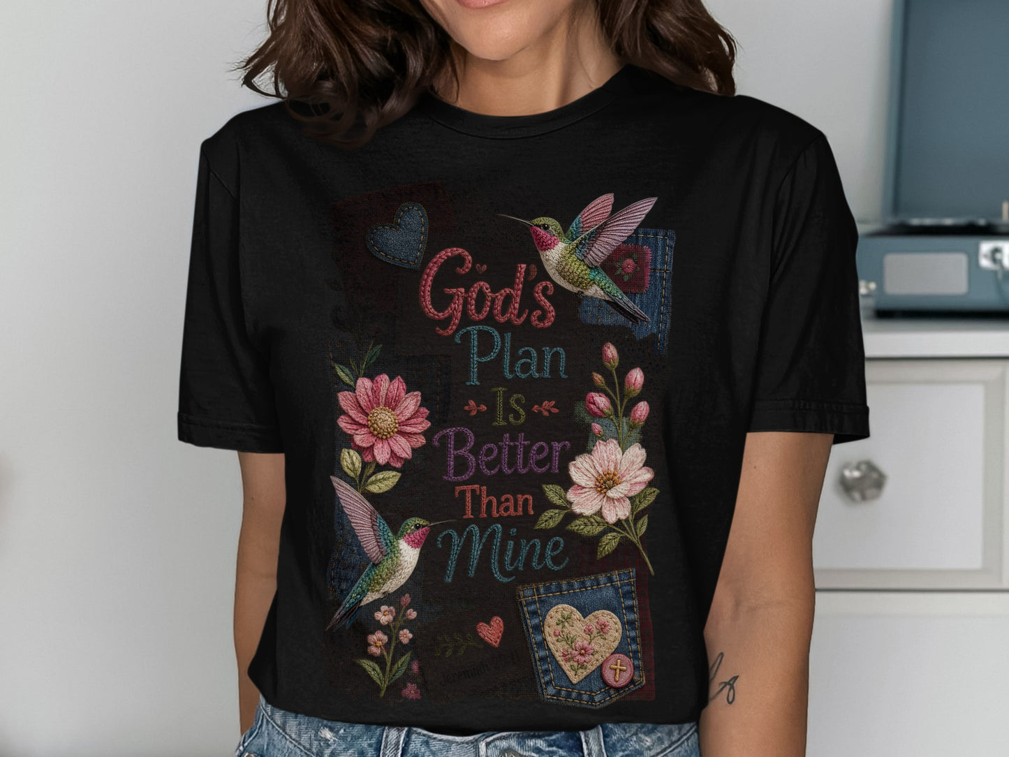 Black t-shirt with floral and hummingbird design and "God's Plan Is Better Than Mine" text.