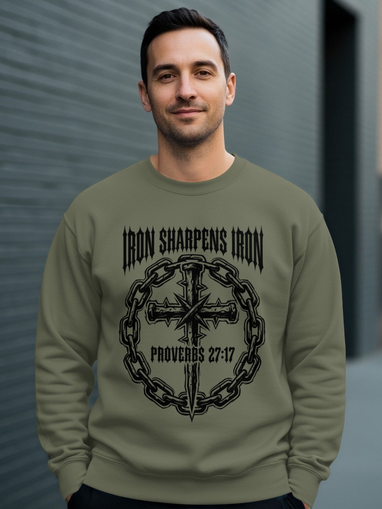 Man wearing olive green sweatshirt with "Iron Sharpens Iron" and cross design.