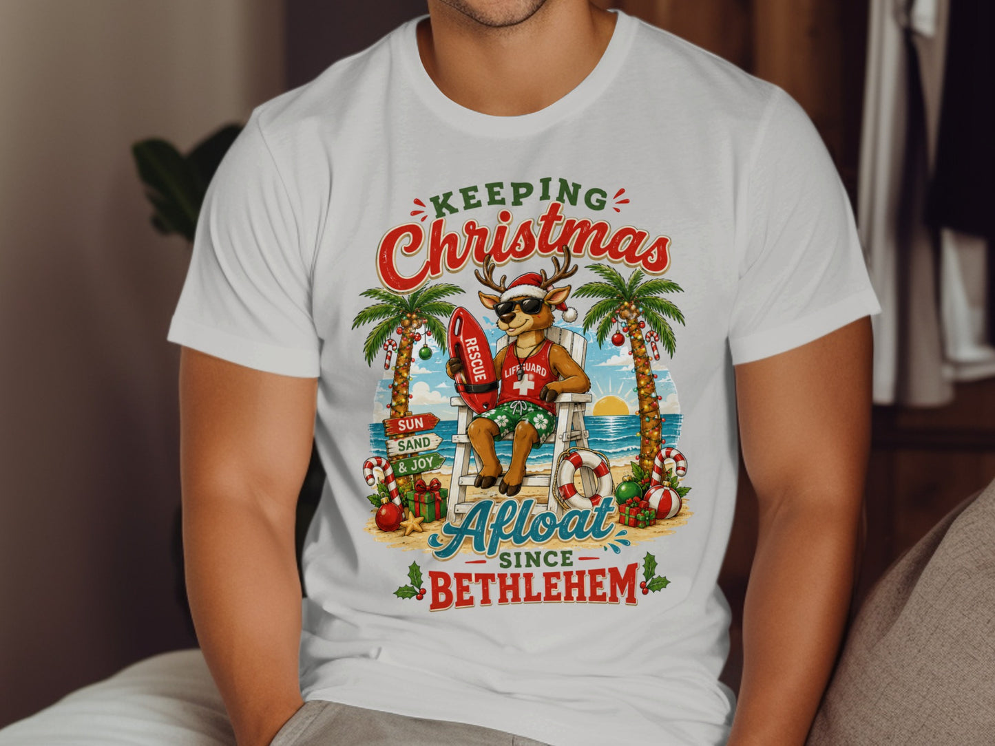 Santa deer lifeguard on beach chair with "Keeping Christmas Afloat Since Bethlehem" text.