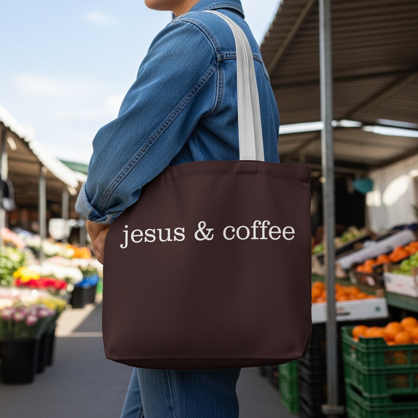 Brown tote bag with white text "jesus & coffee" worn by person.