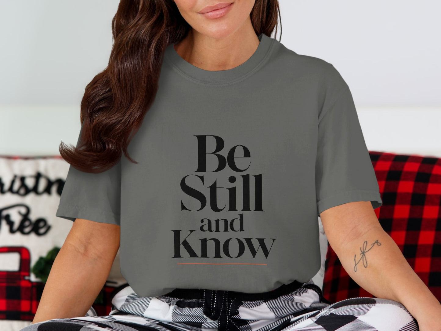 Charcoal t-shirt with "Be Still and Know" text and an orange underline.