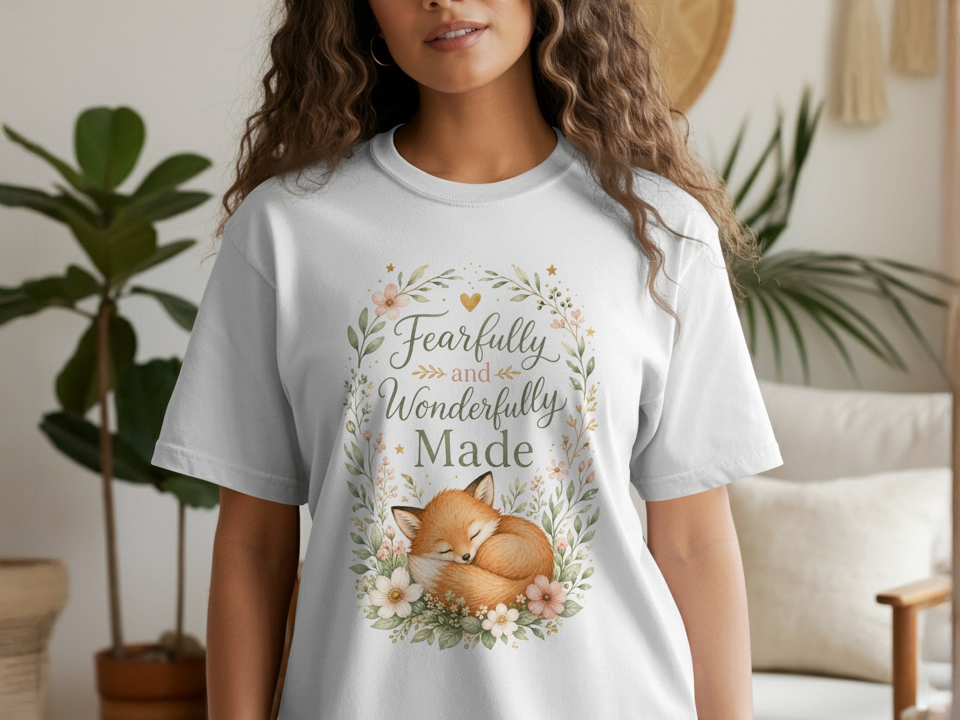 White t-shirt with a floral wreath framing a sleeping fox and the text "Fearfully and Wonderfully Made."