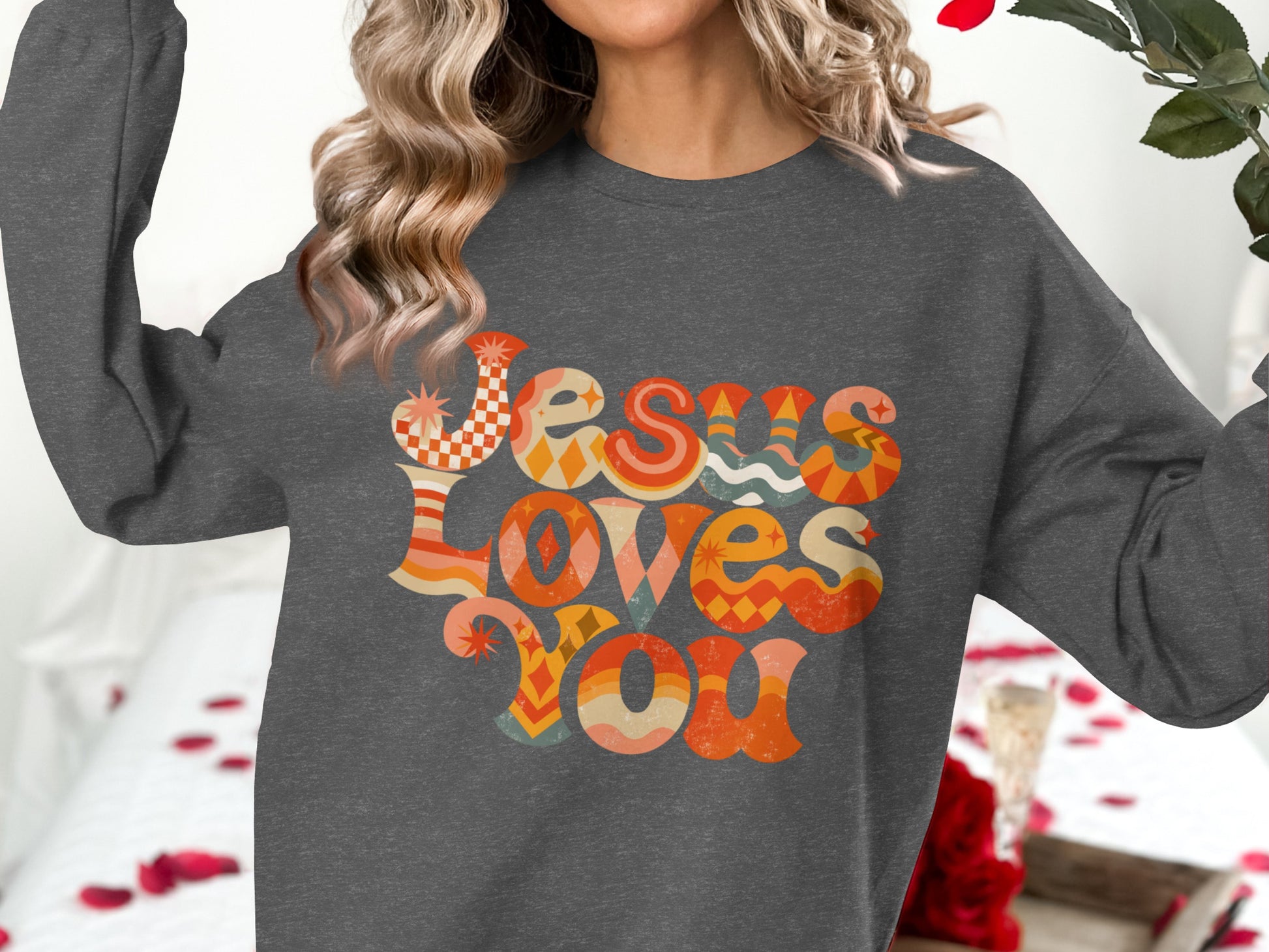 Dark gray sweatshirt with "Jesus Loves You" in colorful retro lettering.