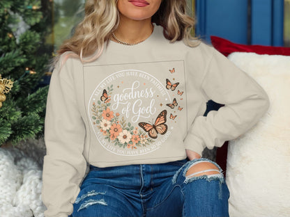 Cream sweatshirt with "goodness of God" and floral butterfly design.