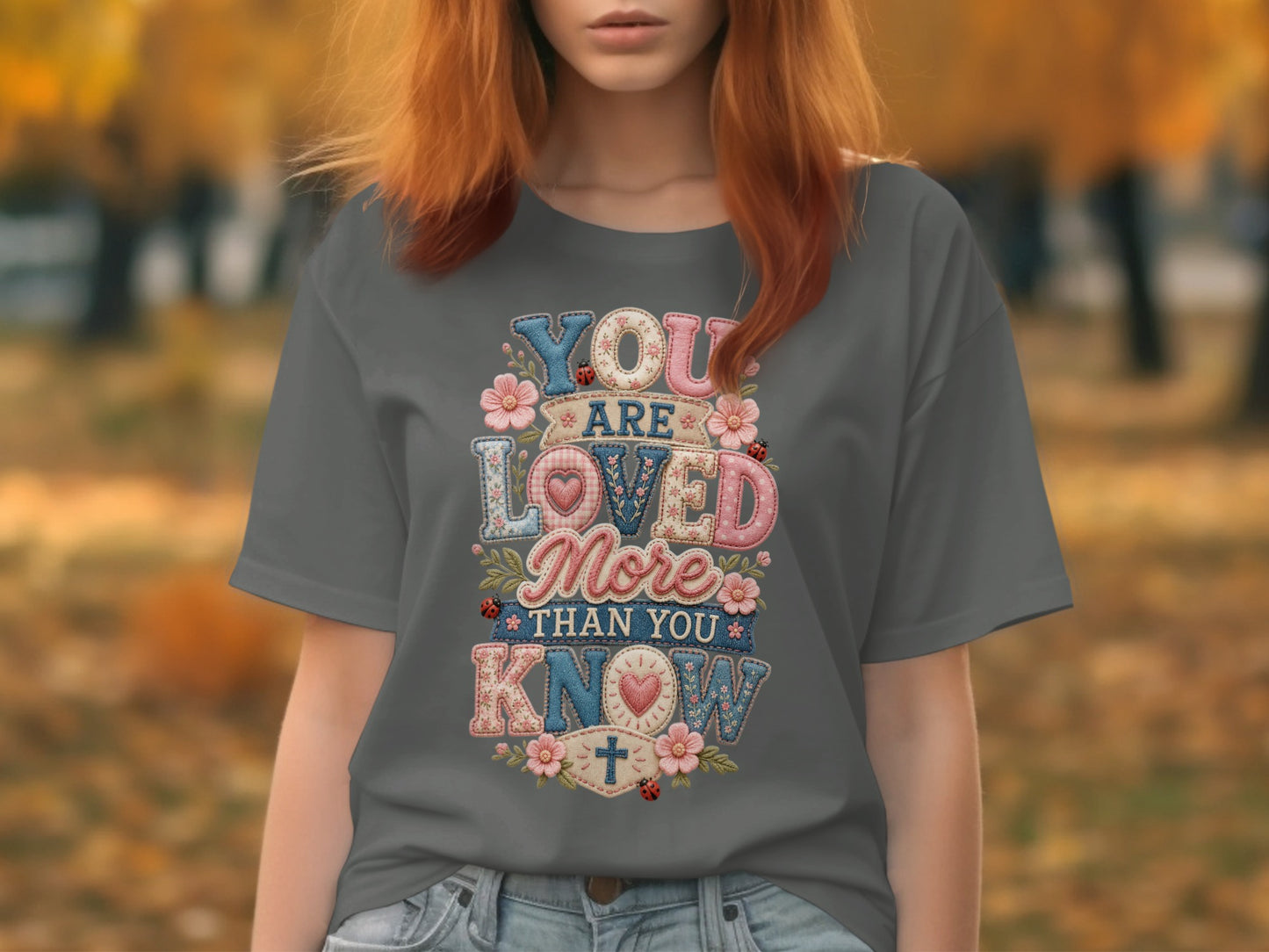T-shirt with colorful "You are loved more than you know" text and floral accents.